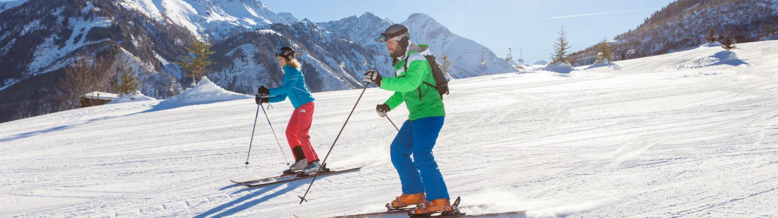 man en vrouw skien op de piste